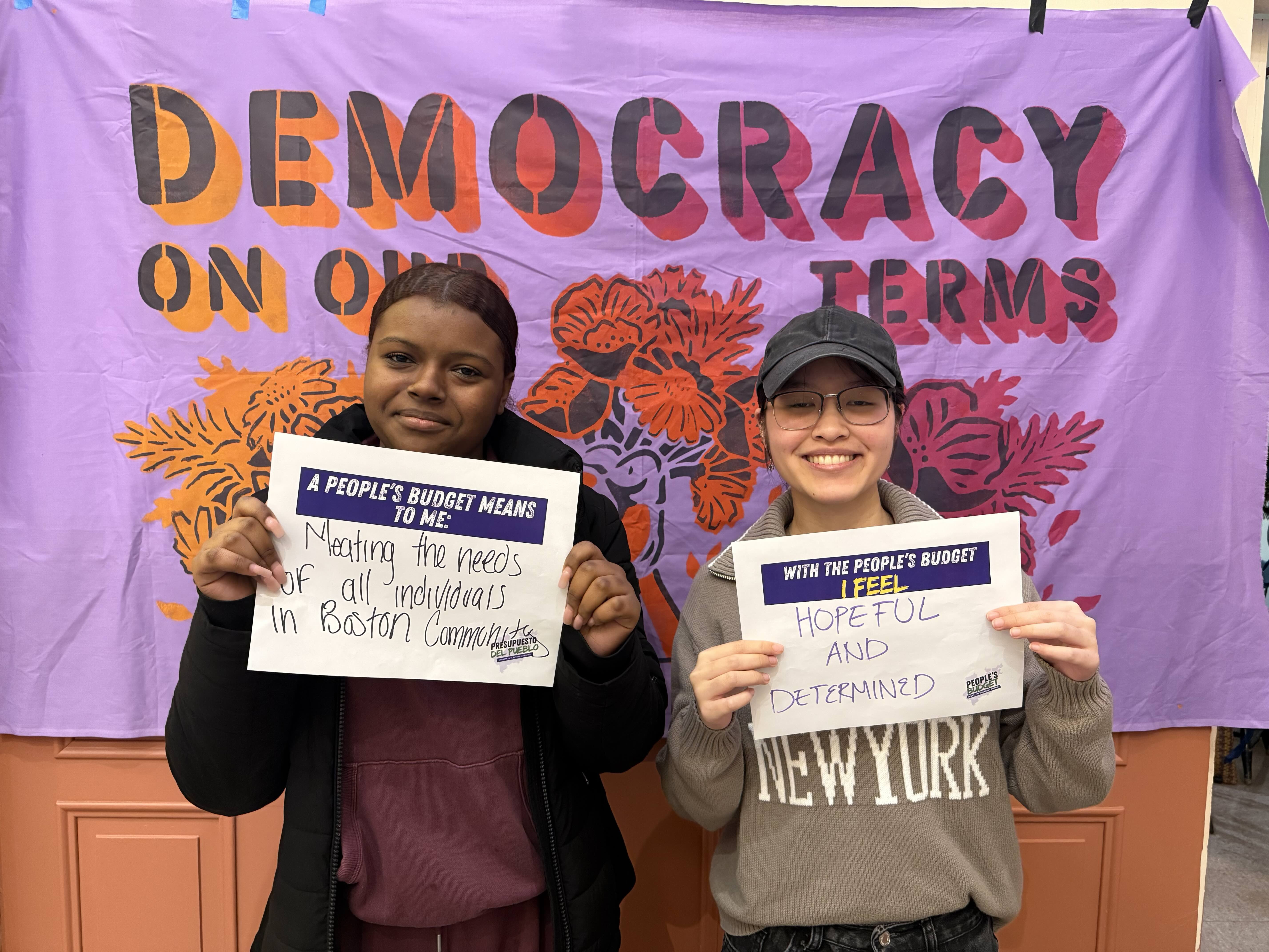 Two people holding signs